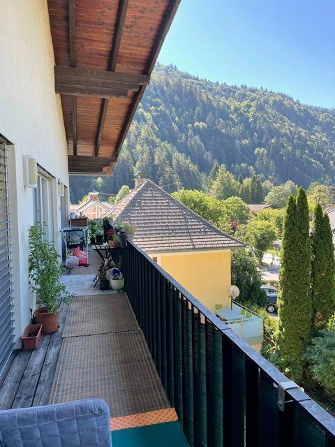 Langer Balkon mit Holzboden und atemberaubendem Blick auf die umliegenden Berge und Wälder.