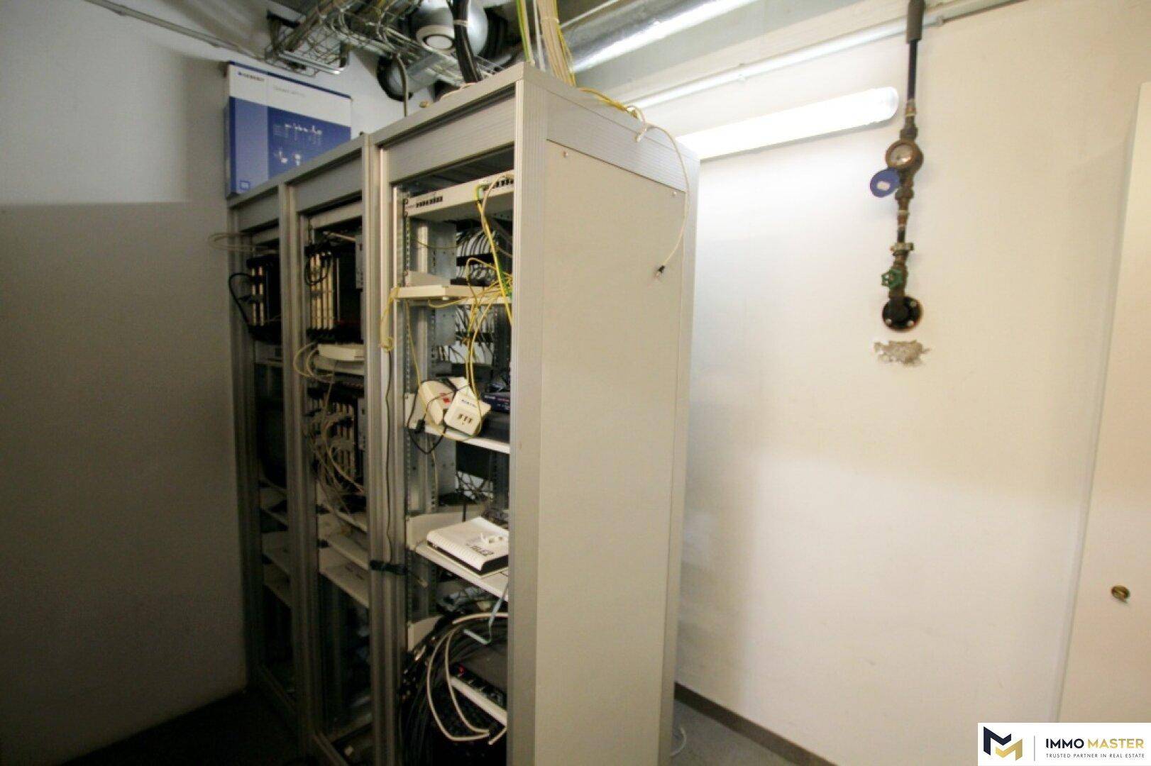 Serverraum mit mehreren Serverschränken und Verkabelung für die technische Infrastruktur.