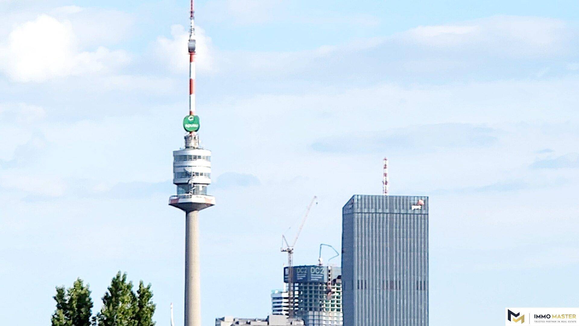 Weitblick über die Stadt mit einem markanten Fernsehturm und modernen Hochhäusern.