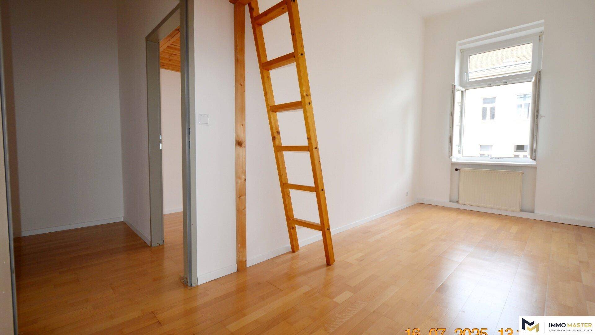 Schlafzimmer mit Holzboden und Fenster, ergänzt durch eine Holzleiter für Hochbettzugang.