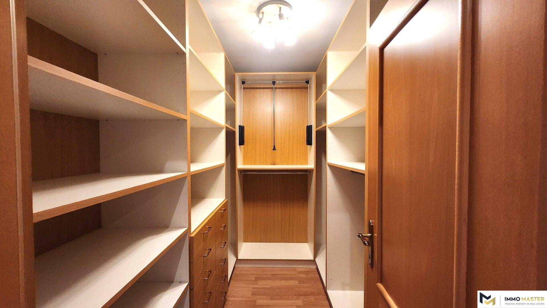 Praktischer begehbarer Kleiderschrank mit vielen Regalen und Aufbewahrungsmöglichkeiten.