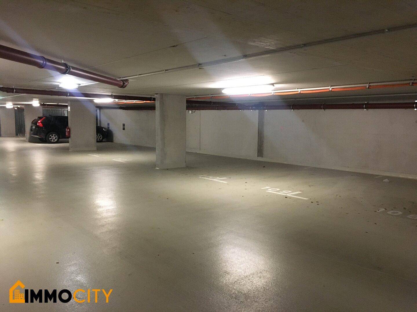 Geräumige Tiefgarage mit Betonboden und ausreichend Stellplätzen für Fahrzeuge.