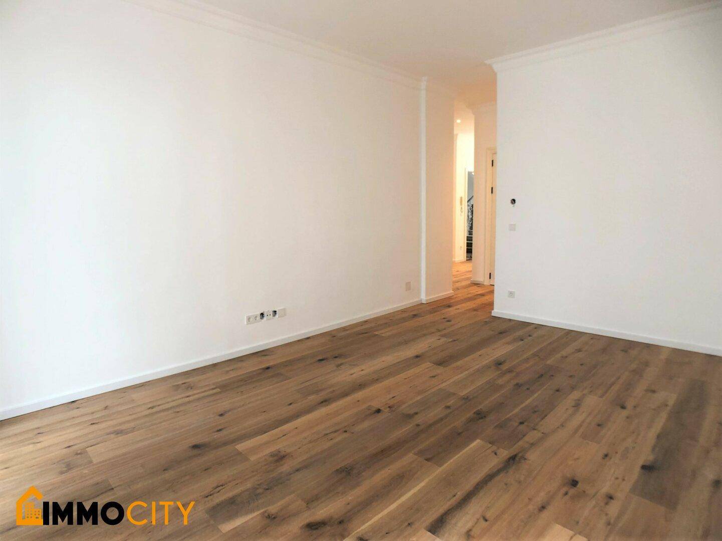 Geräumiges Zimmer mit hellem Holzboden und weiß gestrichenen Wänden, bietet vielseitige Nutzungsmöglichkeiten.