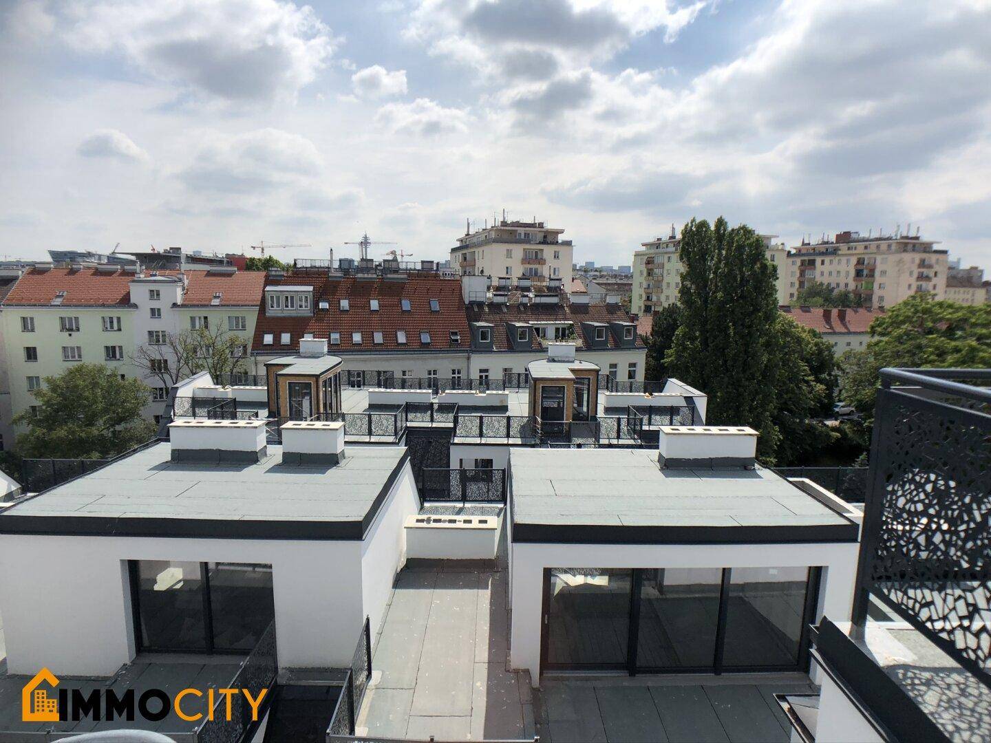 Blick über die Dächer der Stadt mit modernen Dachaufbauten und Flachdächern.