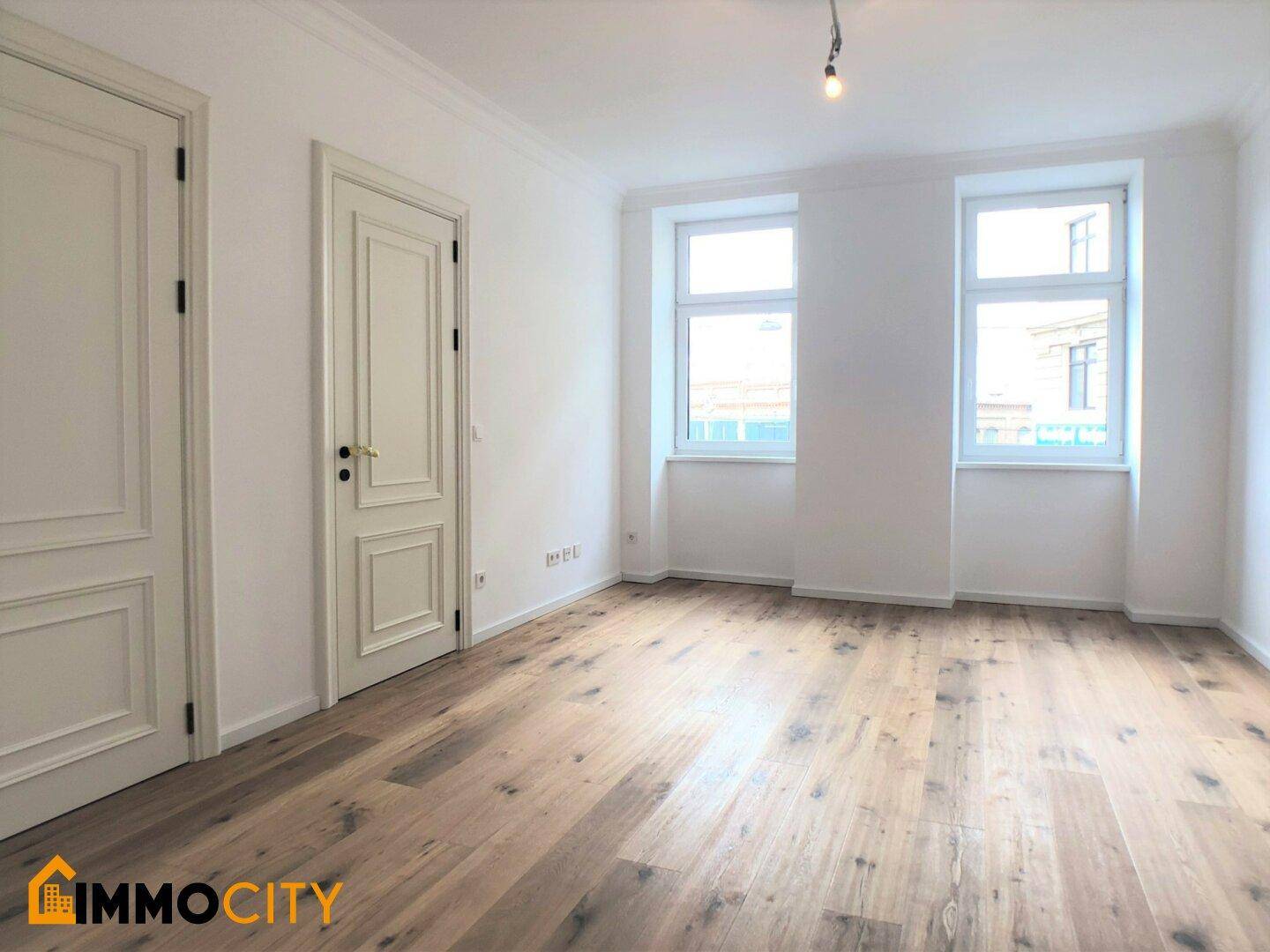 Helles Zimmer mit neuem Holzboden und weißen Wänden, bereit zum Einzug.