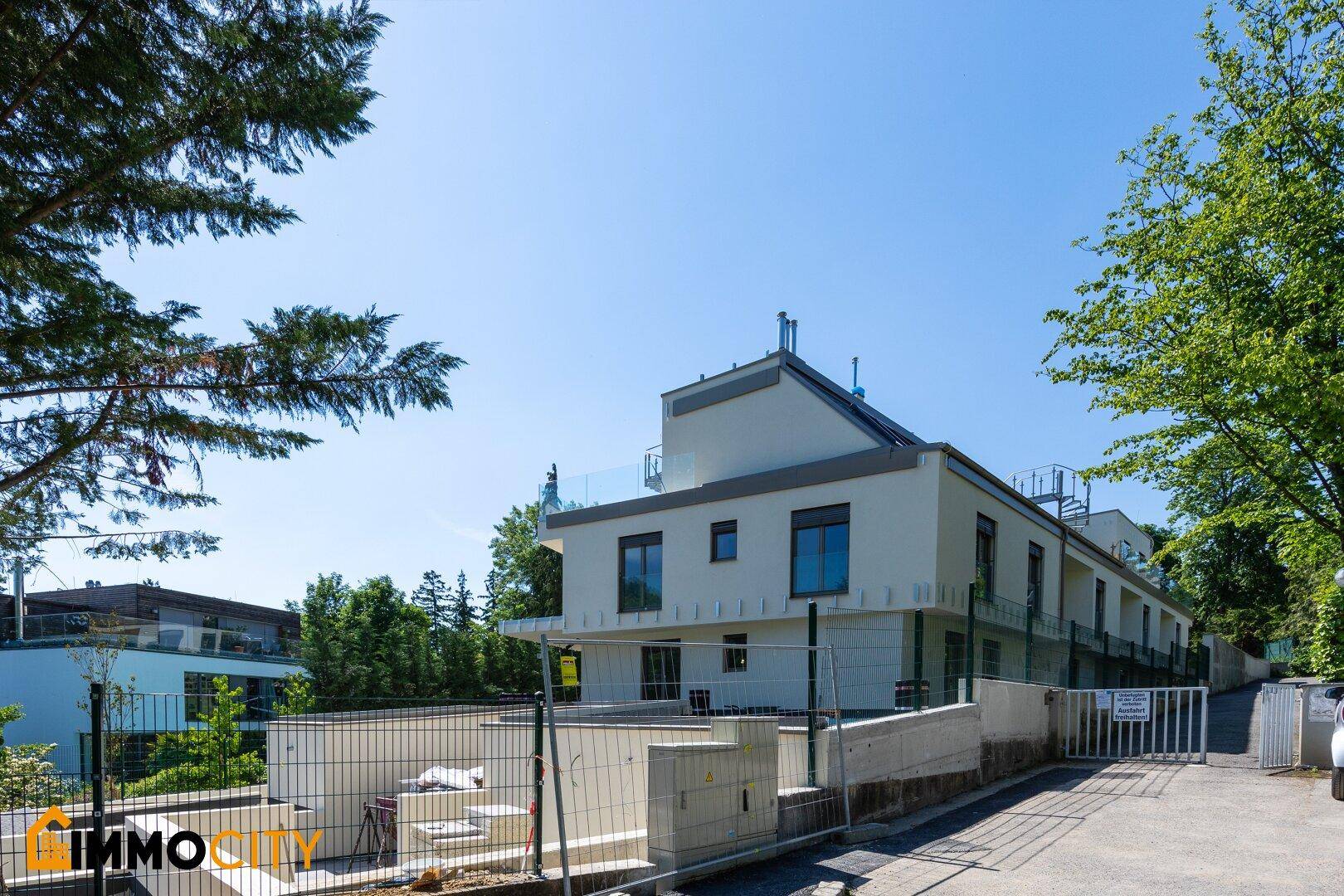 Neubau-Wohngebäude mit moderner Architektur und umliegender Grünfläche im Bau.