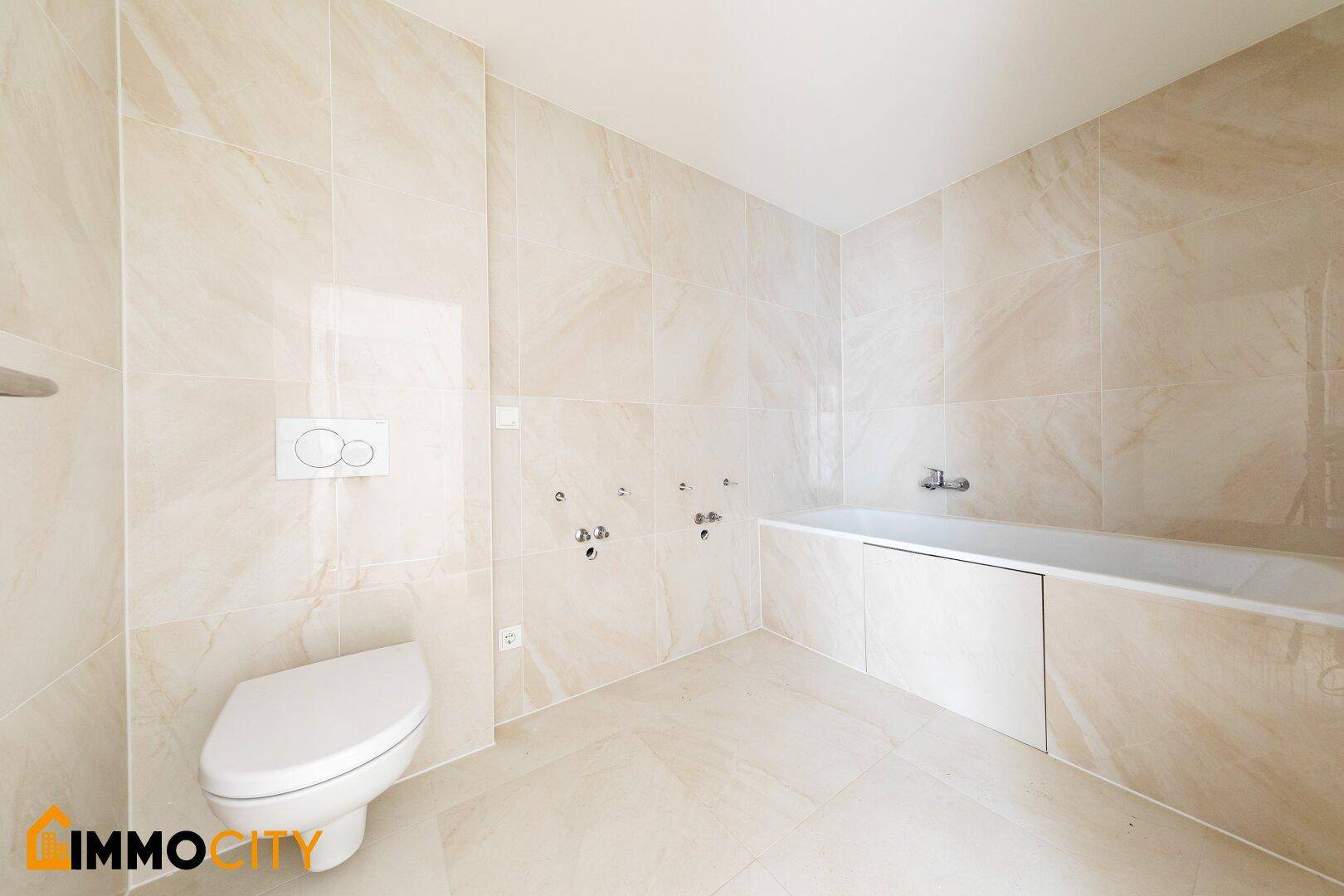 Modernes Badezimmer mit beigefarbenen Fliesen, wandhängendem WC und Badewanne.