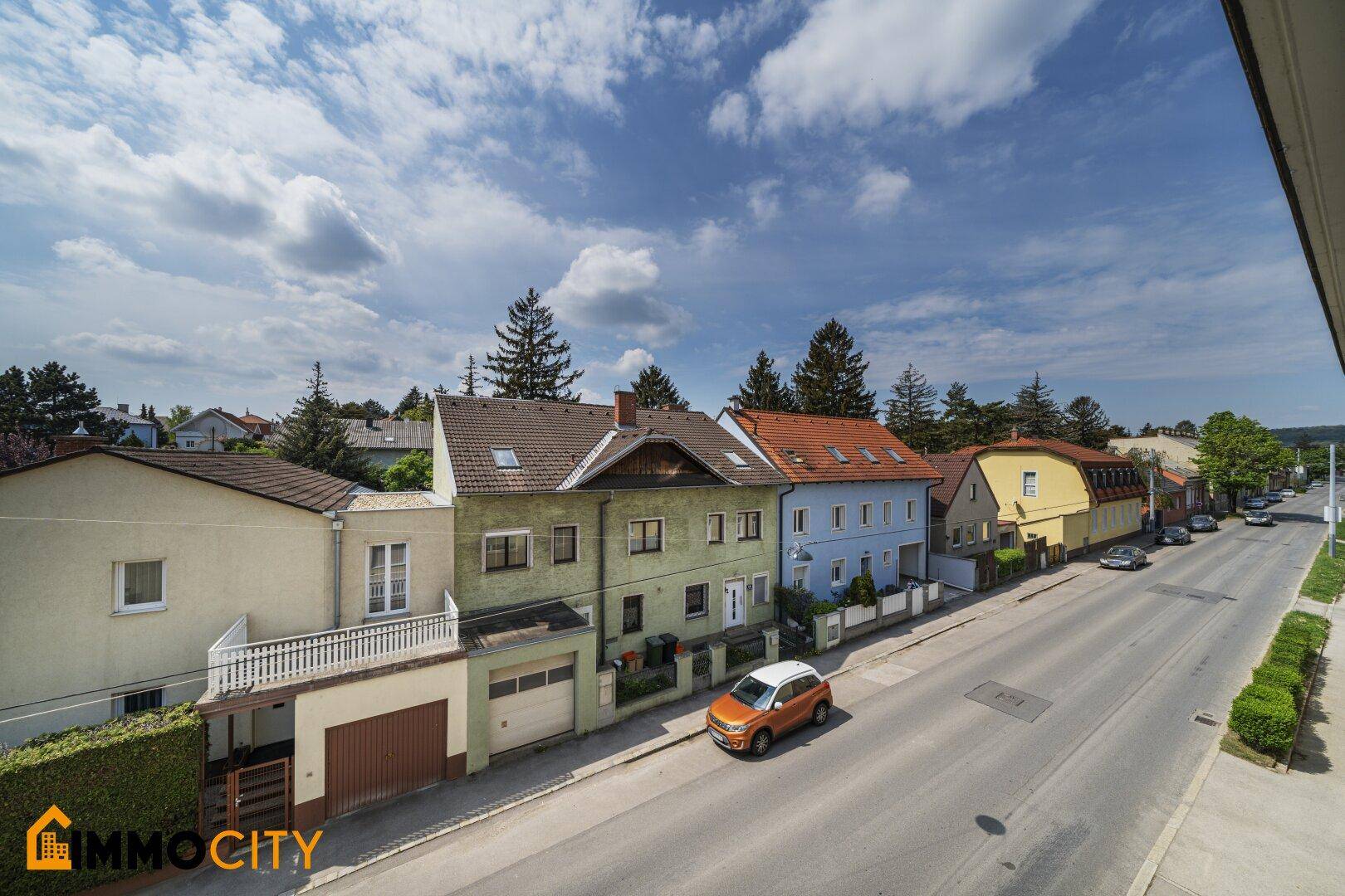 Malerische Wohngegend mit verschiedenen Häusern und viel Grün entlang der Straße.