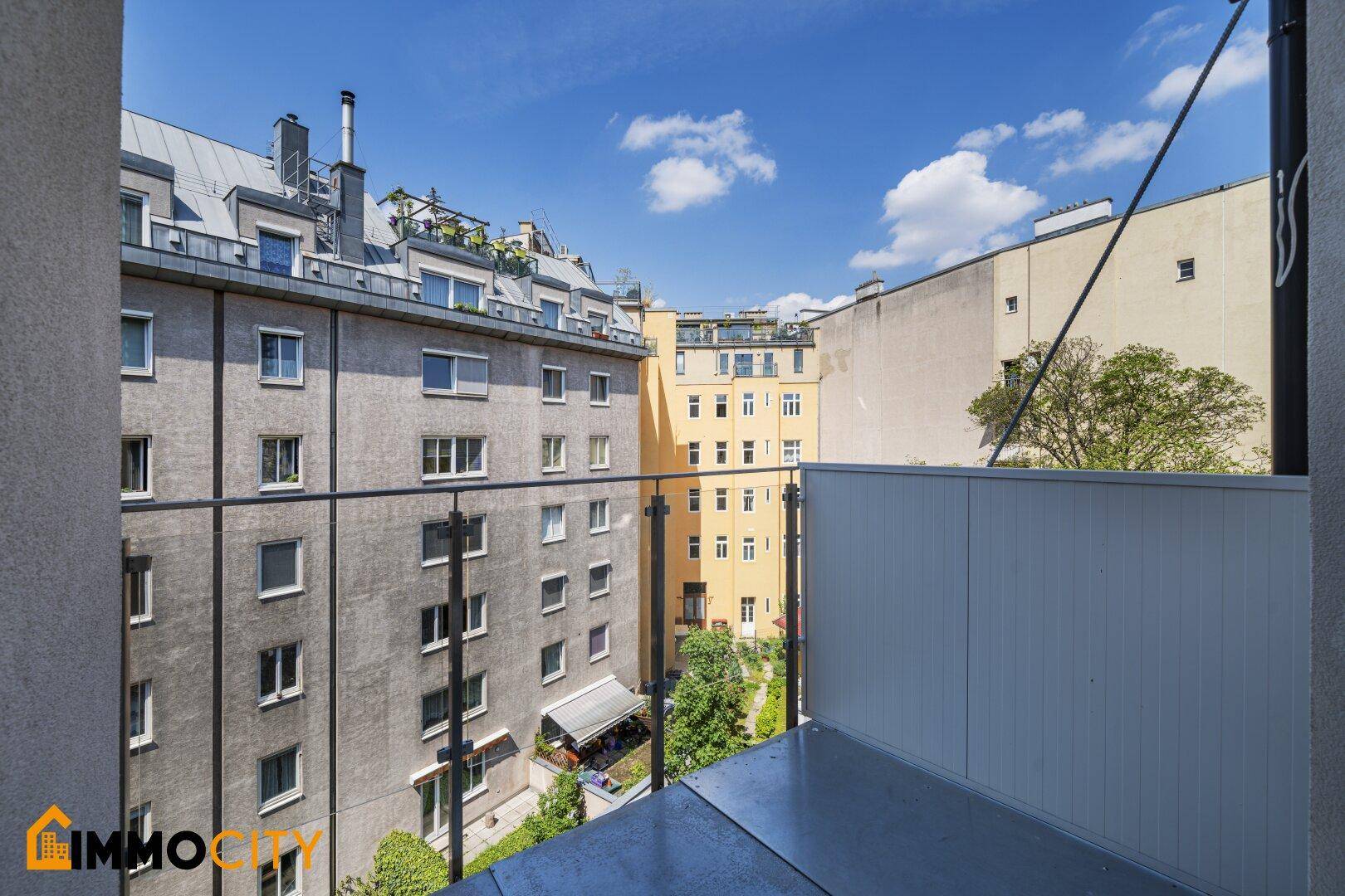 Balkon mit Blick auf den Innenhof und die umliegenden Gebäude.