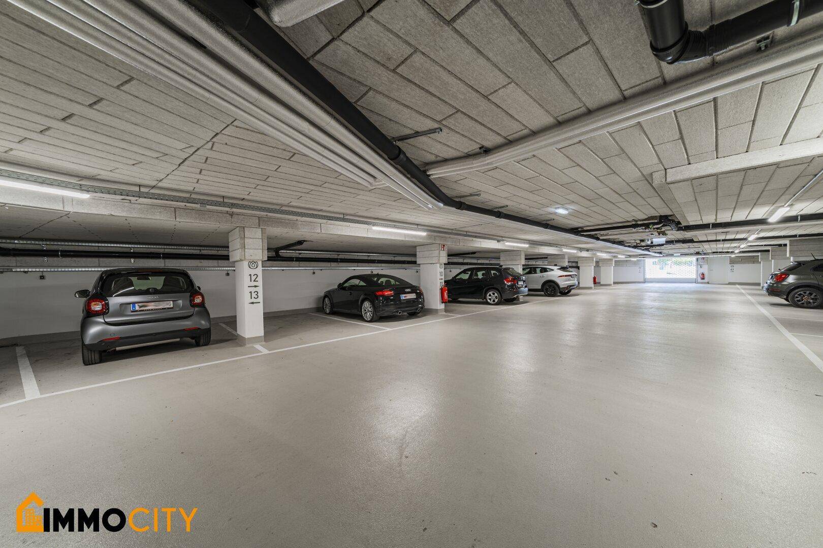 Geräumige Tiefgarage mit mehreren Stellplätzen und moderner Beleuchtung.