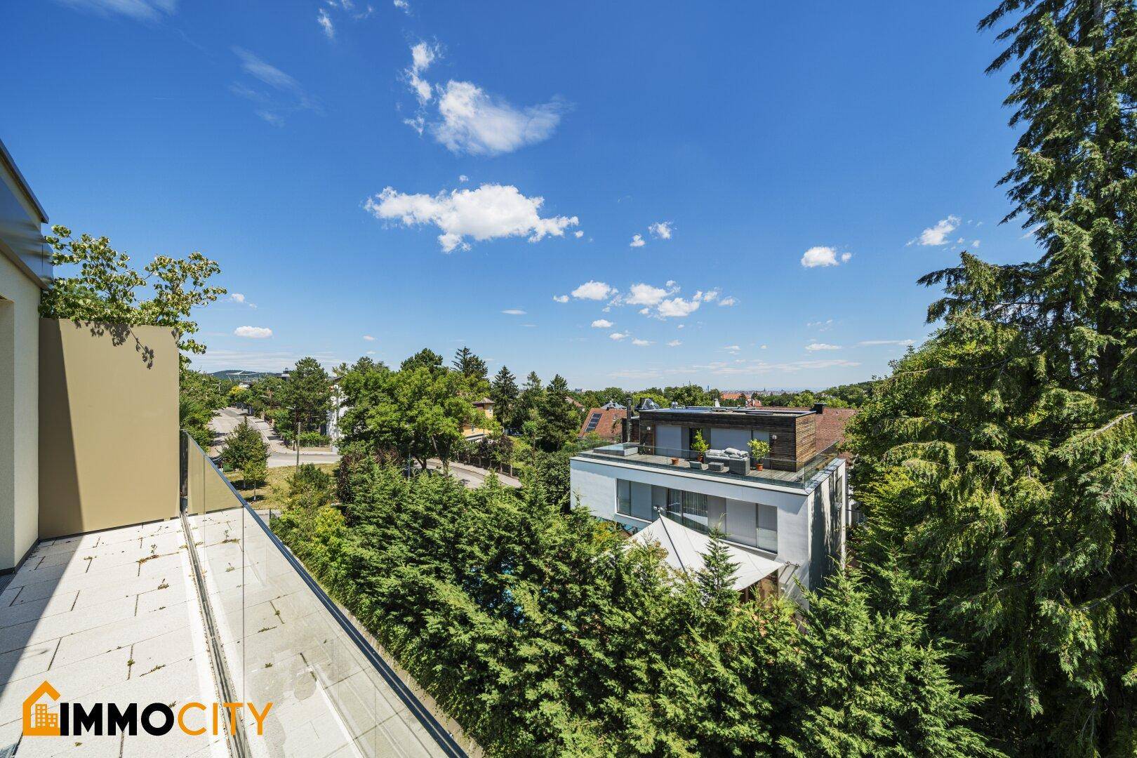 Balkon mit Glasgeländer und weitem Blick über die Umgebung.