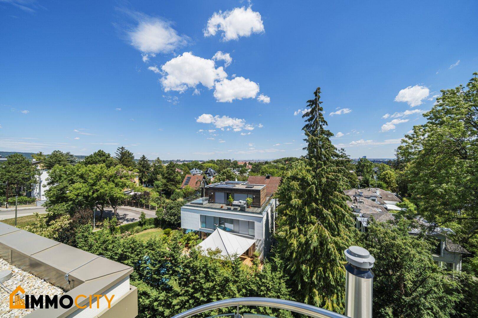 Panoramablick auf das moderne Gebäude und die grüne Umgebung mit Fernsicht auf die Stadt.