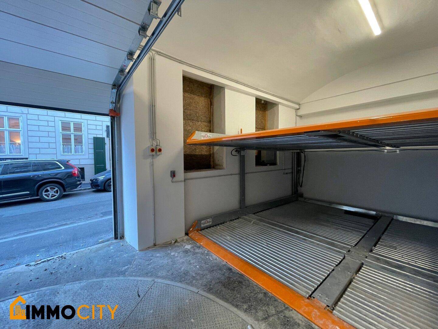 Innenansicht einer modernen Parkgarage mit einem Doppelparker-System und Blick auf die Straße.