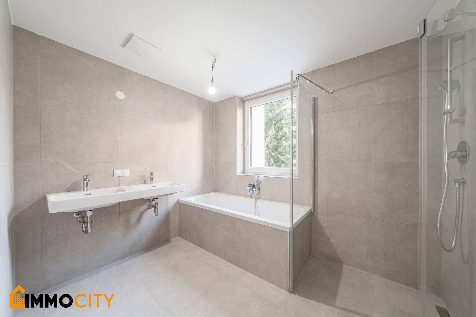 Modernes Badezimmer mit Doppelwaschbecken, Badewanne und separater Dusche.