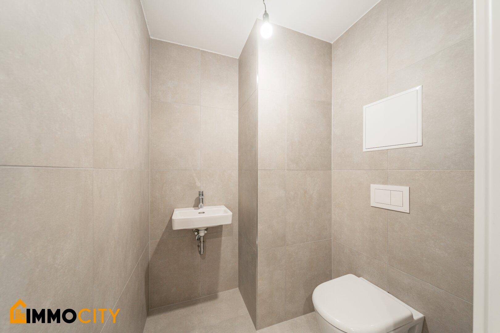 Kompaktes Gäste-WC mit modernem Design und wandmontierter Toilette.