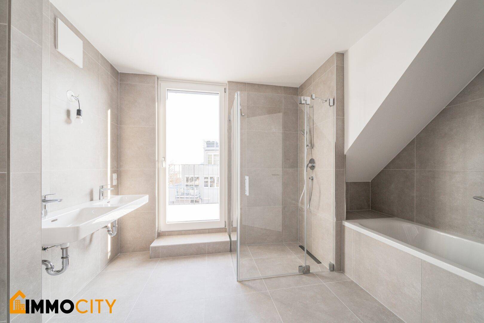 Modernes Badezimmer mit Fliesen, Dusche, Badewanne und Zugang zu einem Balkon.
