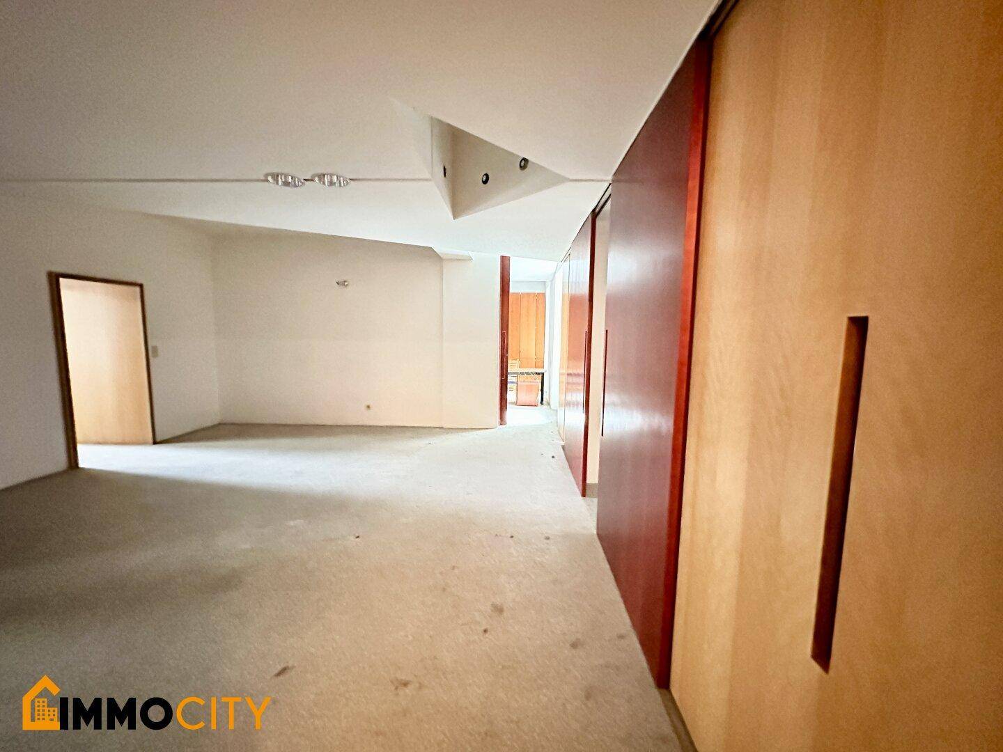 Langer Flur mit Terrazzoboden und modularen Holzschiebetüren, die zu weiteren Räumen führen.