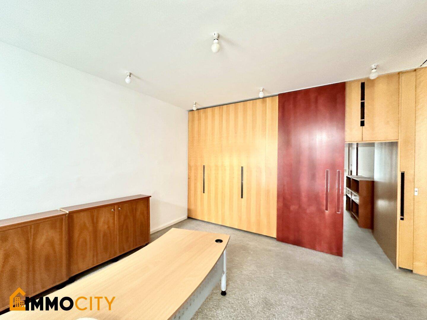 Büro mit Terrazzoboden, Holzschränken und einer großen Schiebetür.