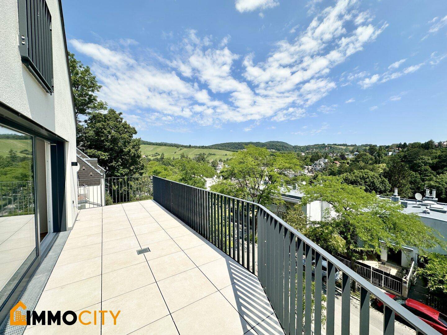 Langer Balkon mit Fliesenboden und Metallgeländer bietet einen schönen Ausblick ins Grüne.