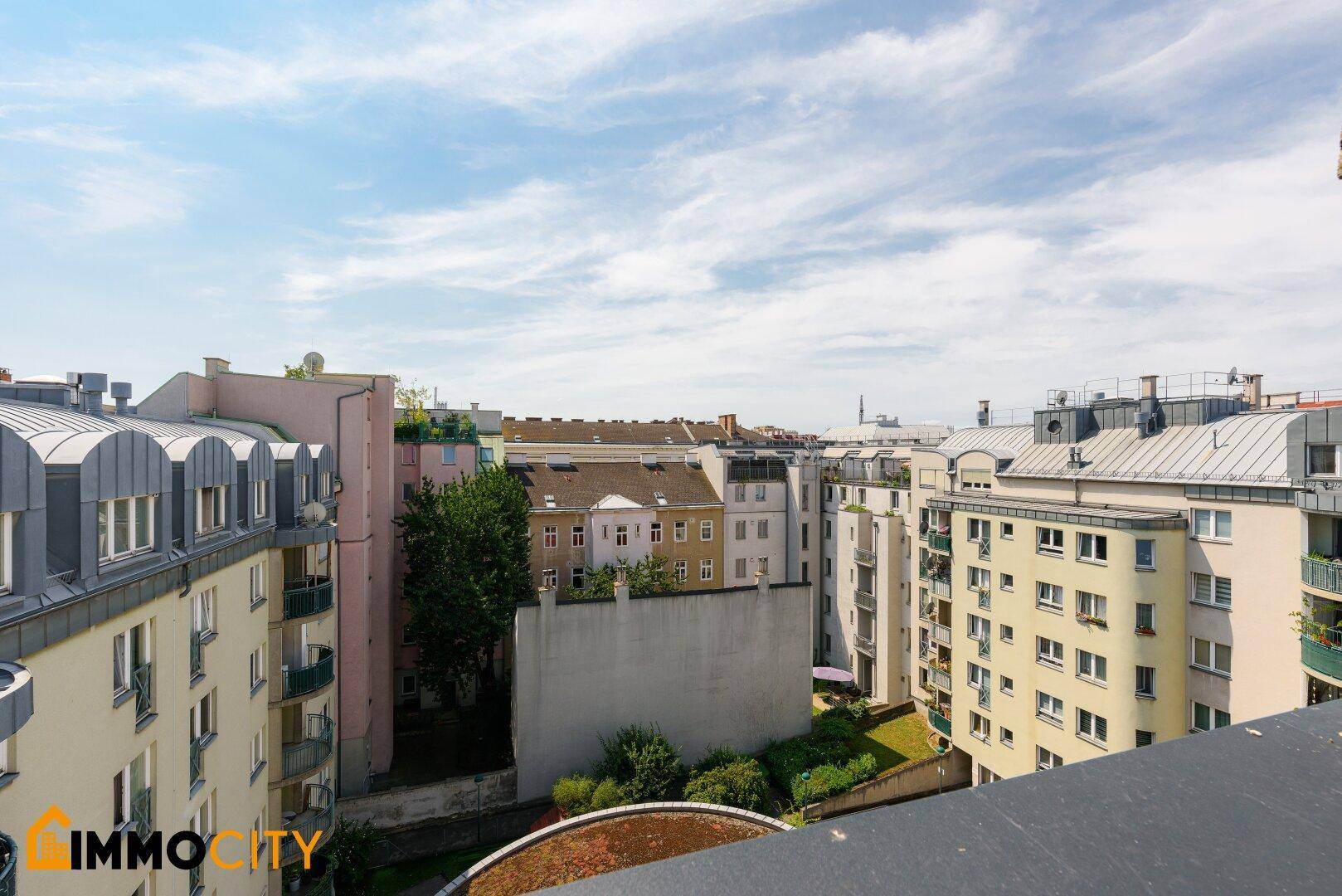 Panoramablick über die Dächer der Stadt mit verschiedenen Gebäuden und Grünflächen.