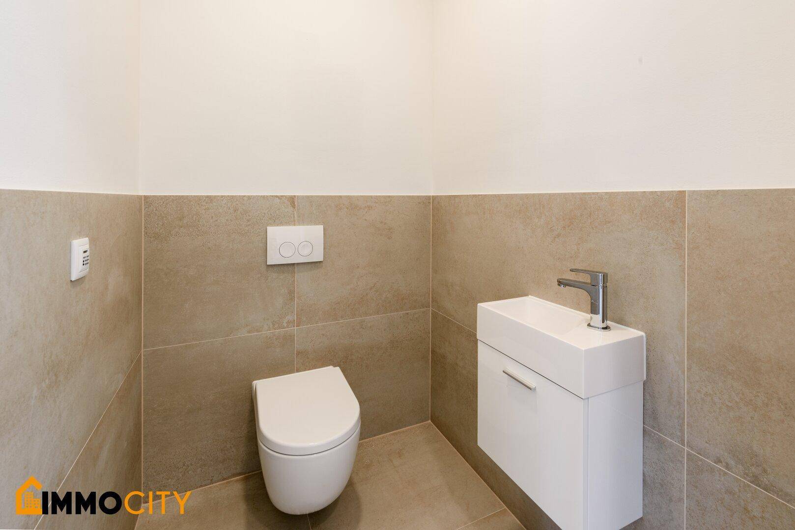 Gäste-WC mit wandhängendem WC und kleinem Waschbecken in modernem Design.