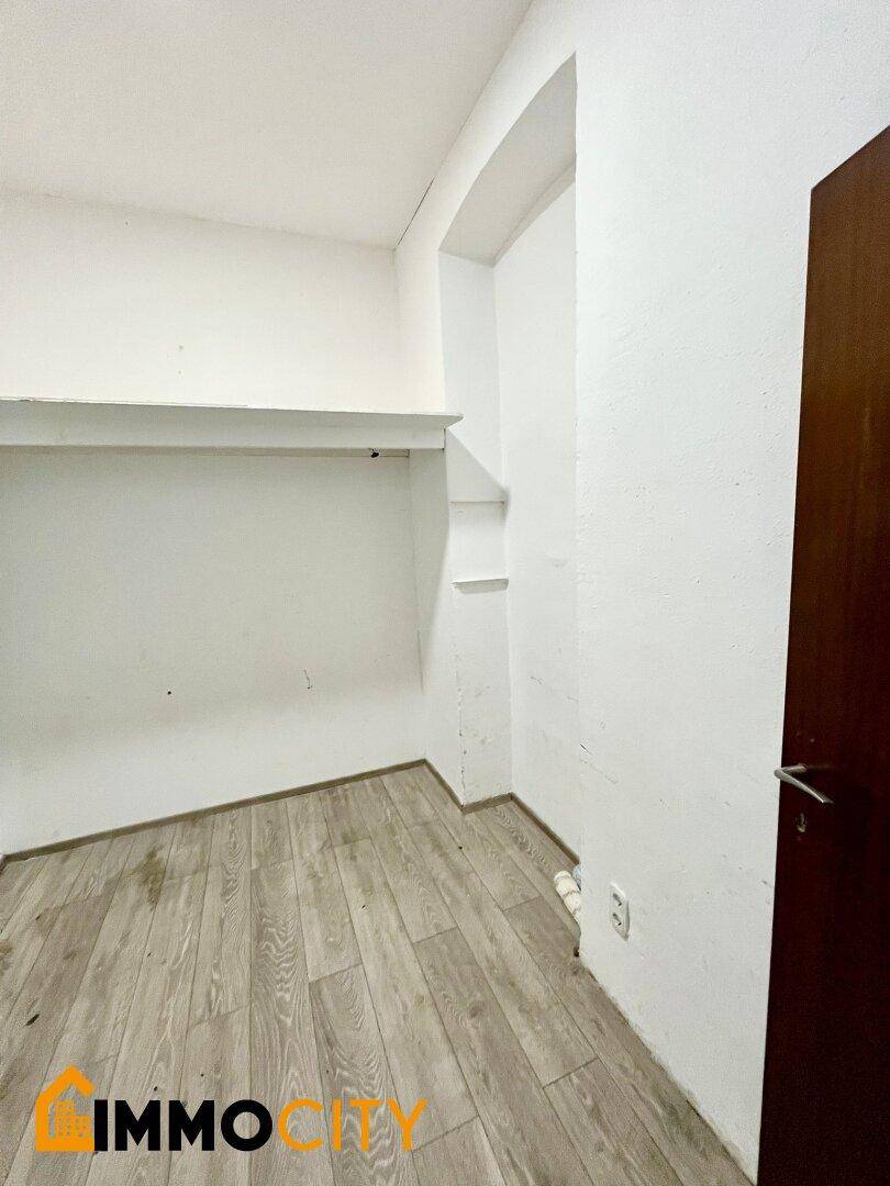 Kleiner Abstellraum mit Laminatboden und einer Ablagefläche an der Wand.