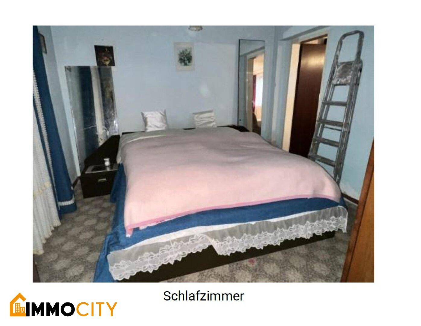 Schlafzimmer mit Doppelbett, Teppichboden und einem großen Spiegel, der den Raum erweitert.