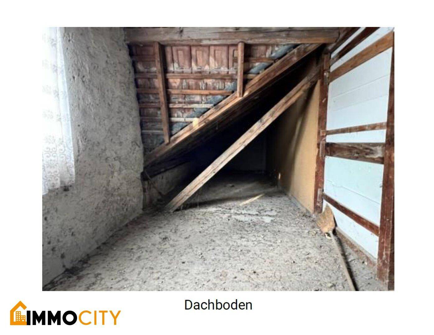 Dachbodenbereich mit schrägen Wänden, Holzbalken und einem Fenster, das Licht spendet.