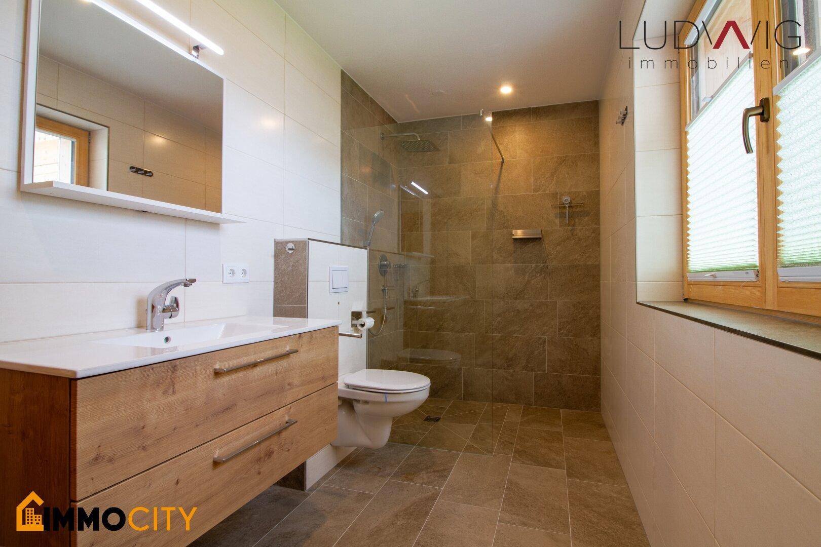Modernes Badezimmer mit begehbarer Dusche, Wand-WC und Holzwaschtisch.
