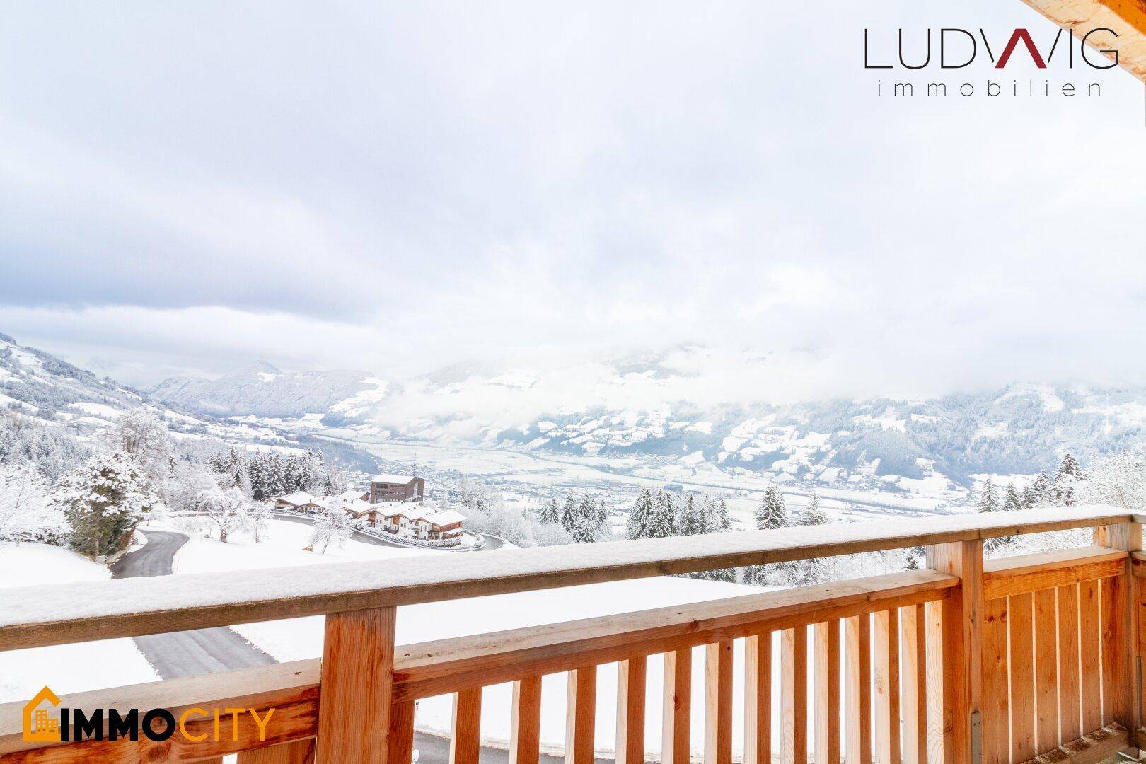 Balkon mit atemberaubendem Panoramablick auf die verschneite Berglandschaft und das Tal.