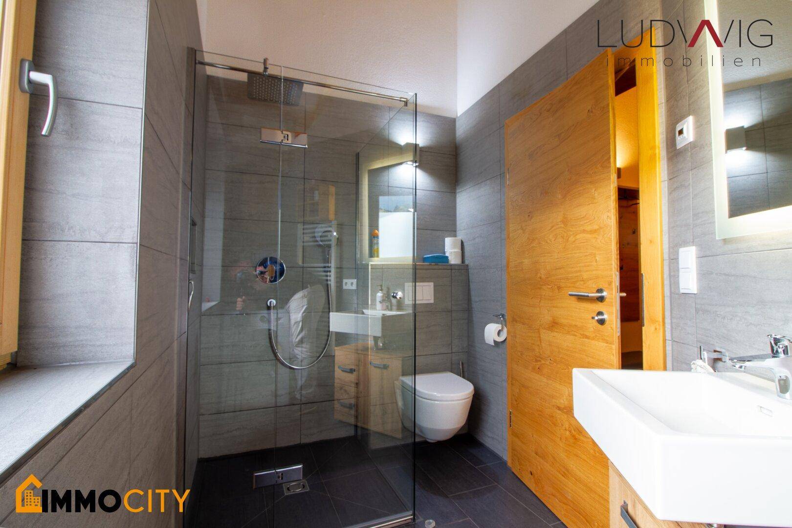 Modernes Badezimmer mit ebenerdiger Dusche, Einzelwaschbecken und Fenster.