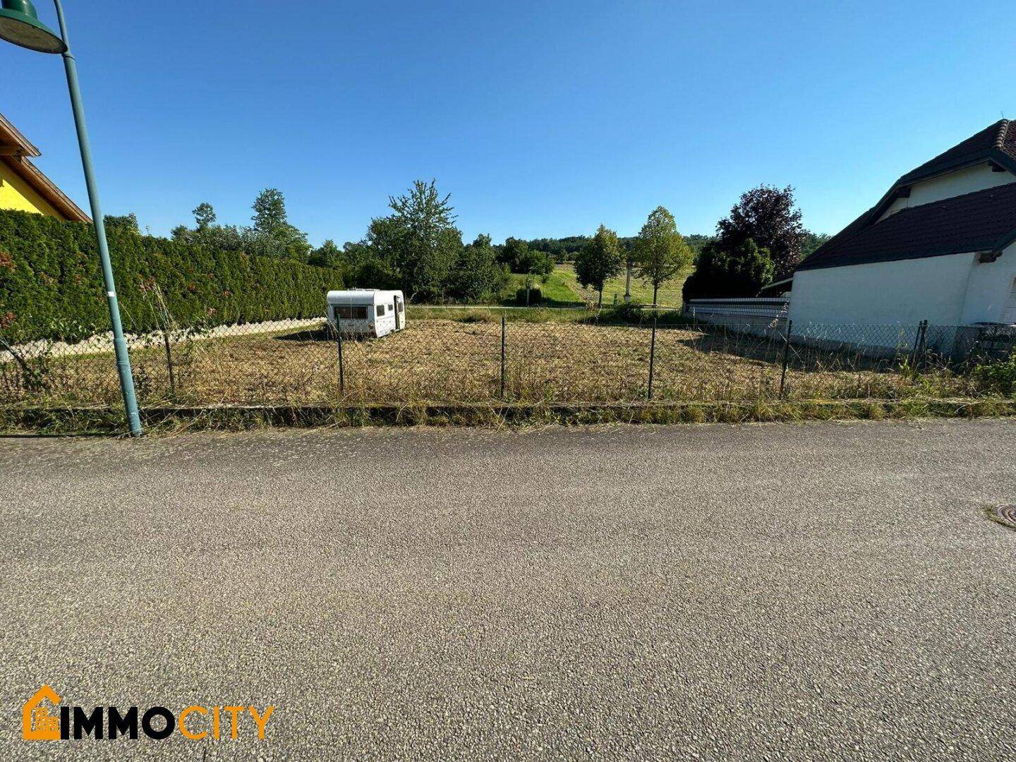 Weitläufiges Grundstück mit Blick auf die grüne Umgebung und angrenzende Straße.