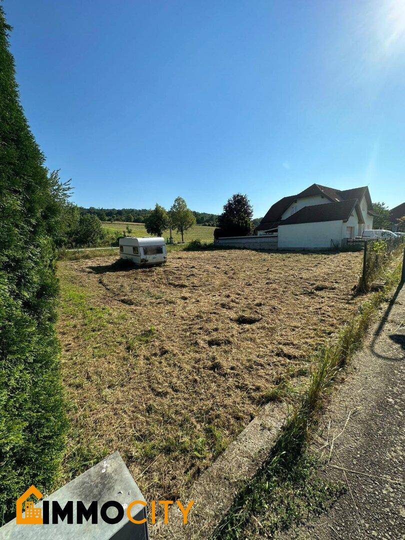 Großes Grundstück mit freiem Blick auf die hügelige Landschaft und angrenzende Häuser.