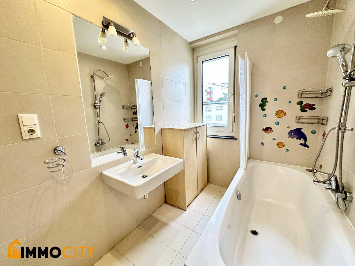 Badezimmer mit Badewanne, Dusche, Waschbecken, Fenster und einem praktischen Handtuchheizkörper.