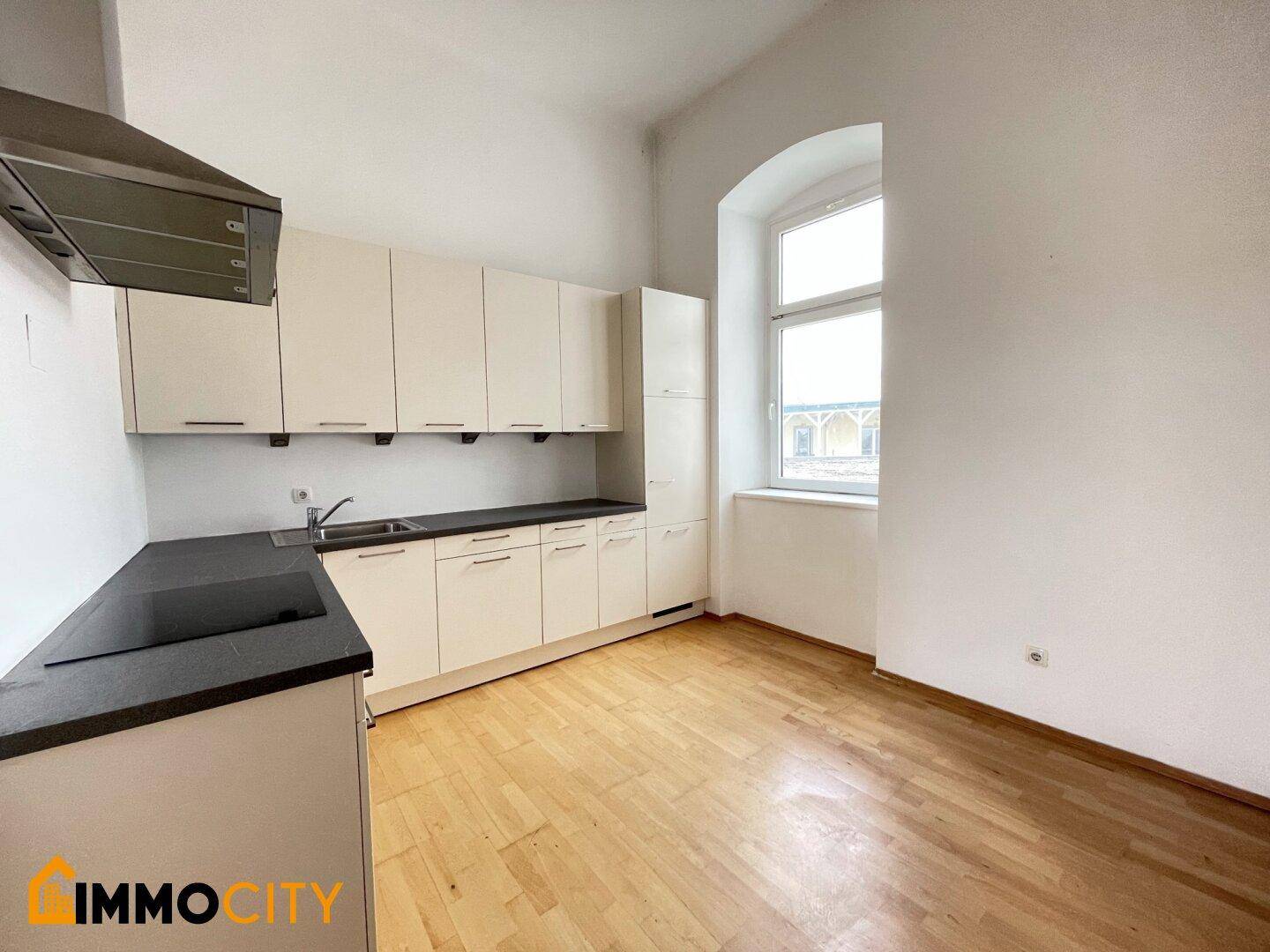 Helle Küche mit Fenster, ausgestattet mit praktischen Schränken und Arbeitsflächen.
