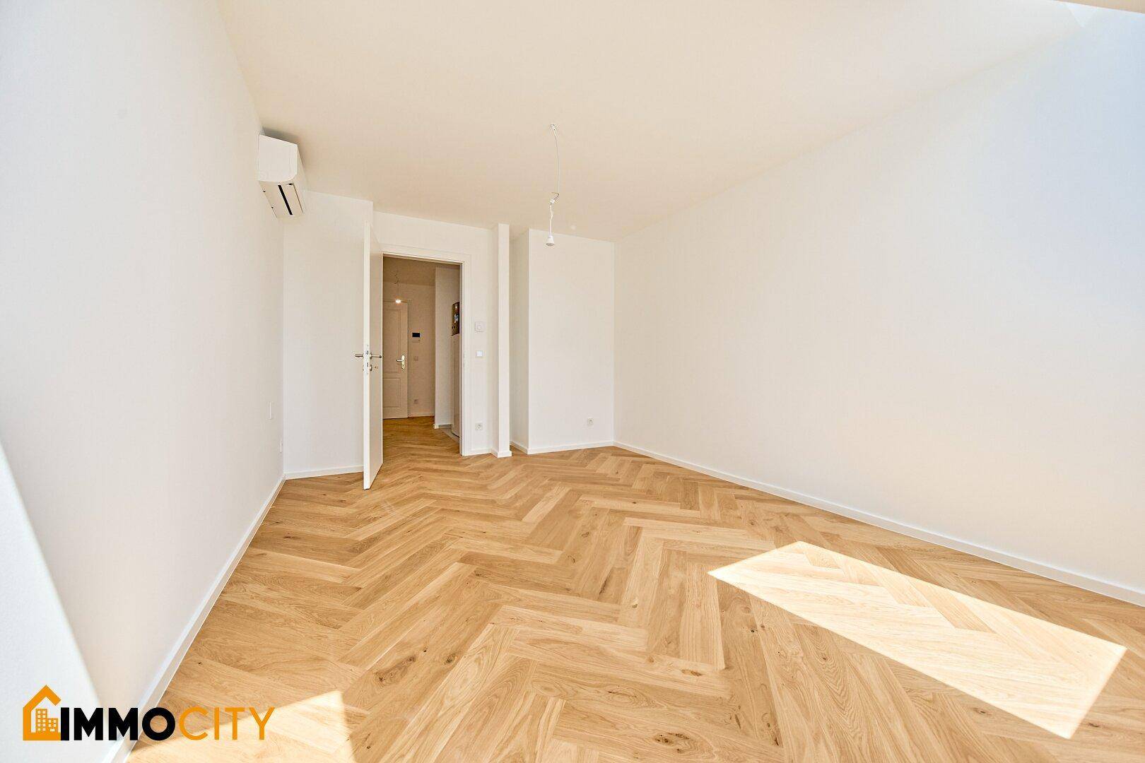 Geräumiges Zimmer mit Fischgrätparkett und viel Tageslicht, ideal als Schlafzimmer oder Büro.