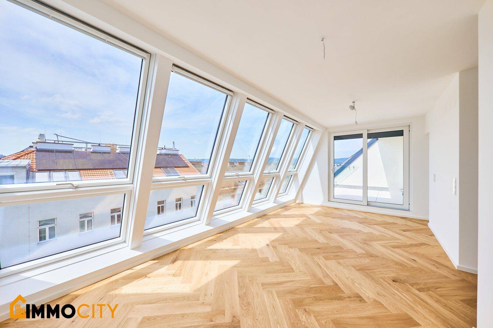 Geräumiges, helles Zimmer mit großen Dachfenstern und Fischgrätparkett, bietet weite Aussicht.