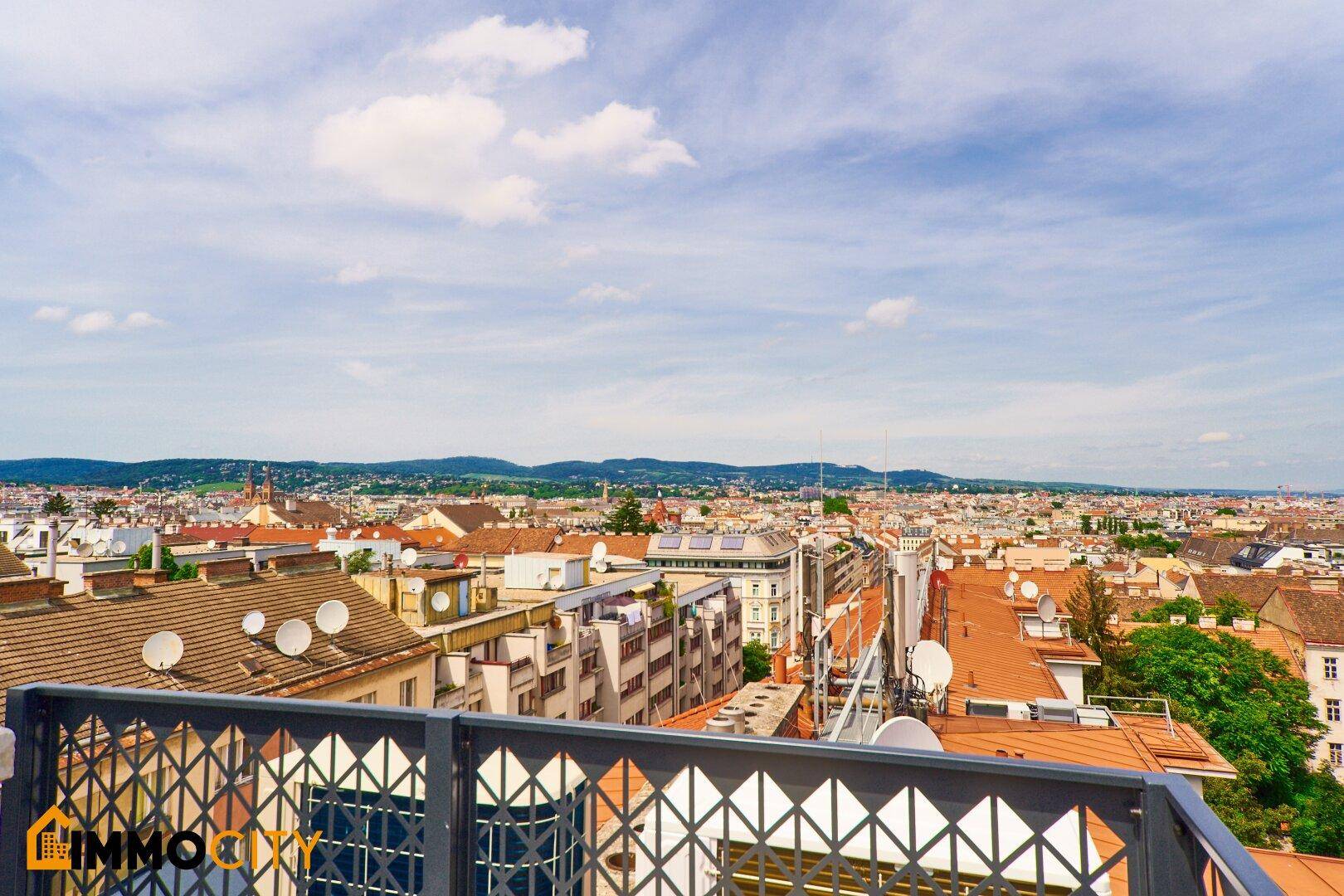 Weitläufige Dachterrasse mit modernem Geländer und Panoramablick über die Stadt.