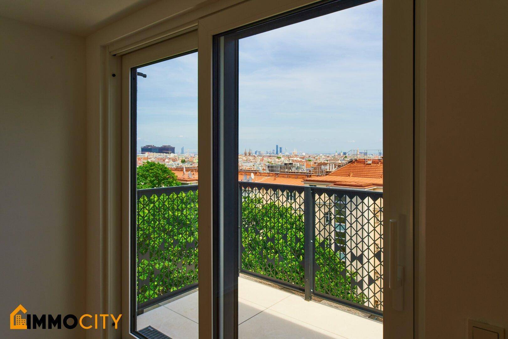 Heller Balkon mit Blick über die Stadt und moderne Metallbrüstung, ideal zum Entspannen.