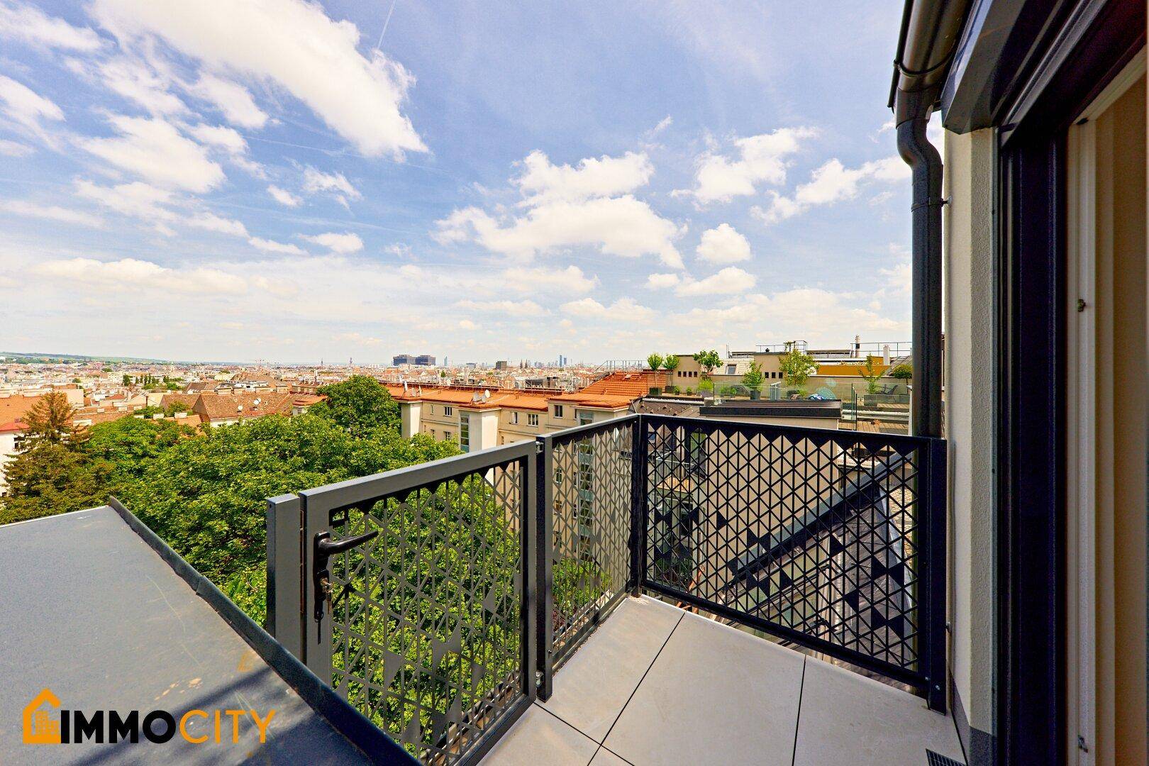 Balkon mit Fliesenboden und dekorativem Geländer, bietet einen weiten Blick über die Stadt.