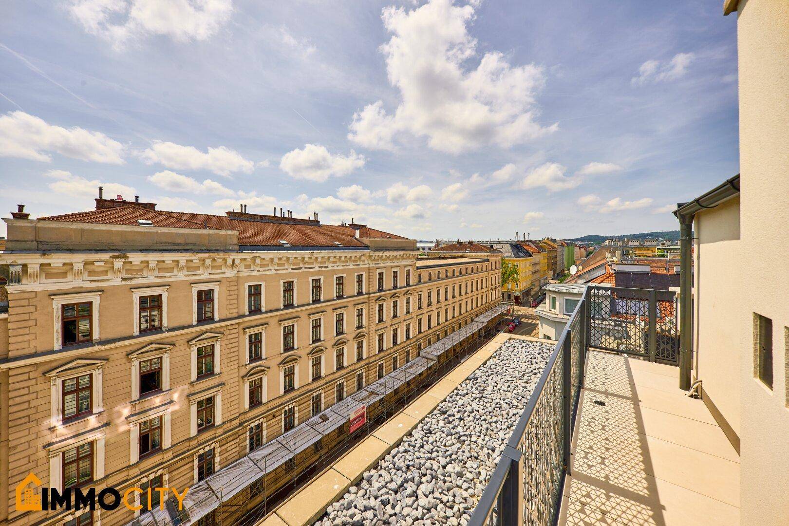 Langer, schmaler Balkon mit Kiesdekor und Blick auf die historische Stadtstraße.