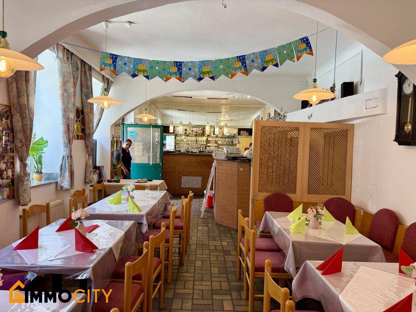Blick durch den Restaurant-Essbereich zur Bar, mit festlich dekorierten Tischen und Stühlen.