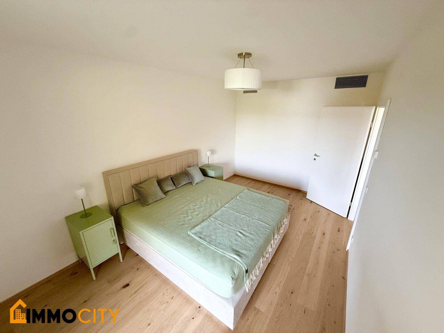 Geräumiges Schlafzimmer mit hellem Holzboden und schlichter, moderner Einrichtung.