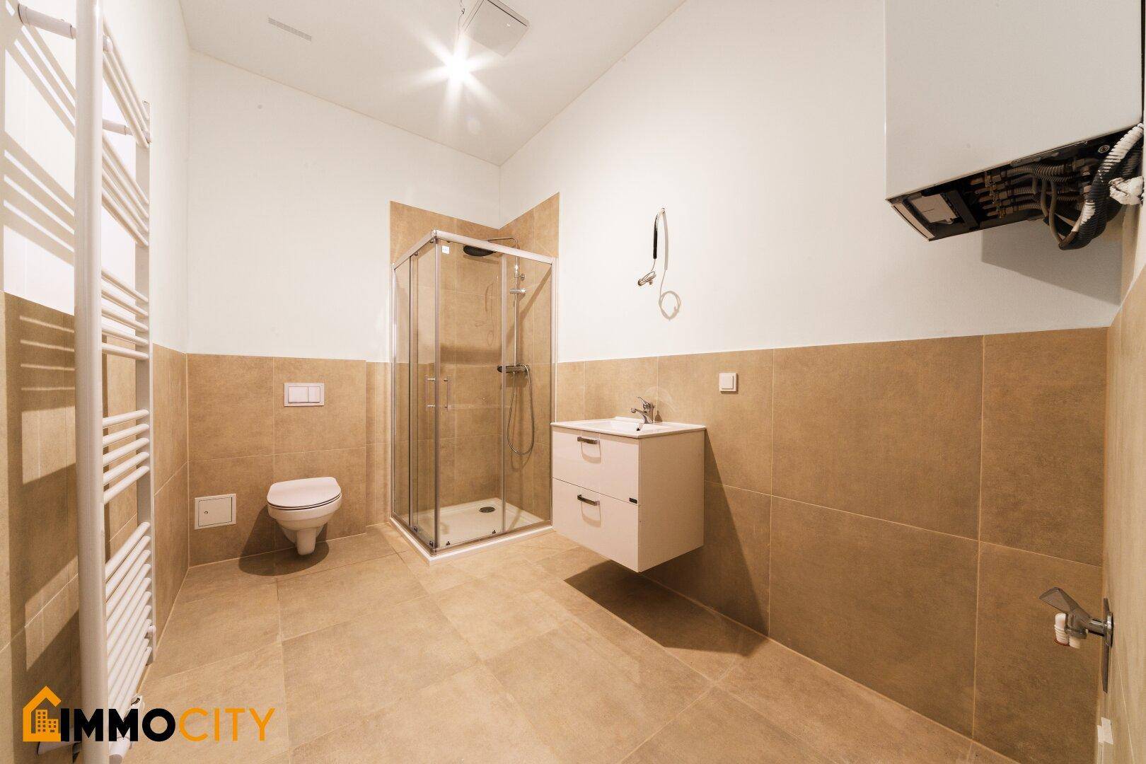 Modernes Badezimmer mit Duschkabine, WC, Waschtisch und Handtuchheizkörper.