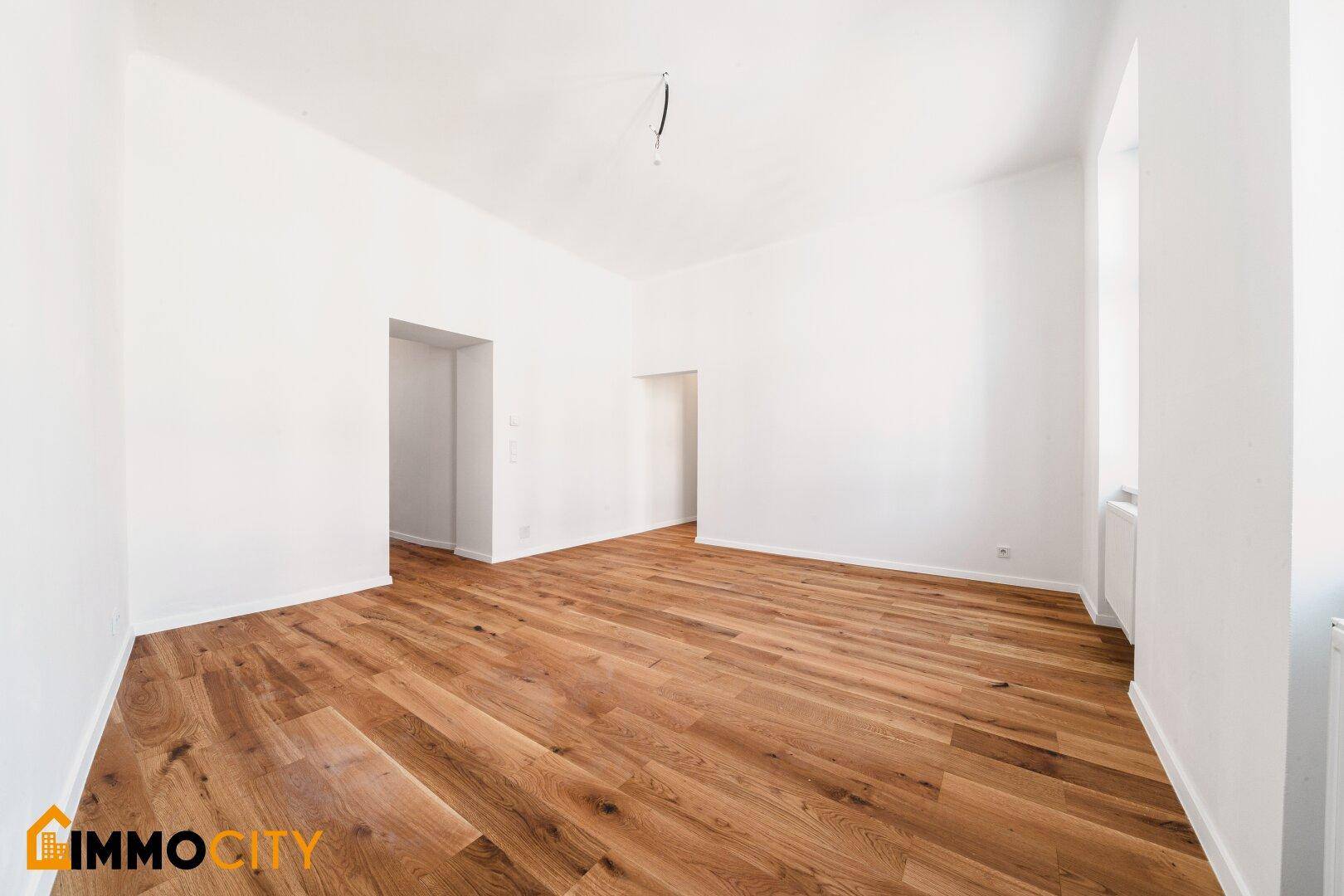 Geräumiges Zimmer mit Holzboden und viel Tageslicht, ideal für individuelle Gestaltung.