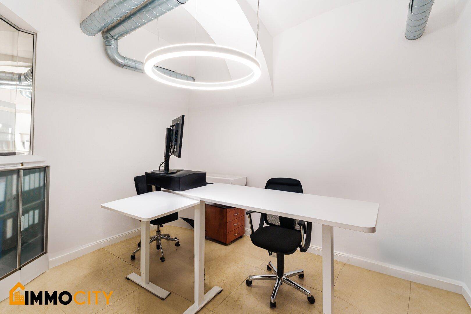 Einzelbüro mit modernem Schreibtisch, ergonomischem Stuhl und runder Deckenleuchte.