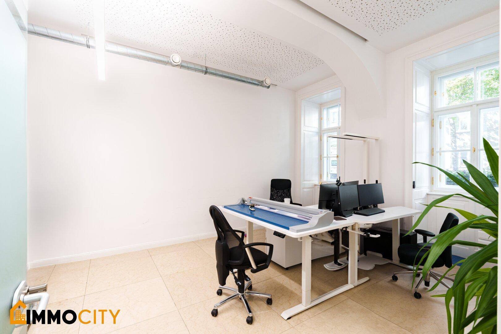 Moderner Bürobereich mit Glaswänden, großen Fenstern und Blick nach draußen.