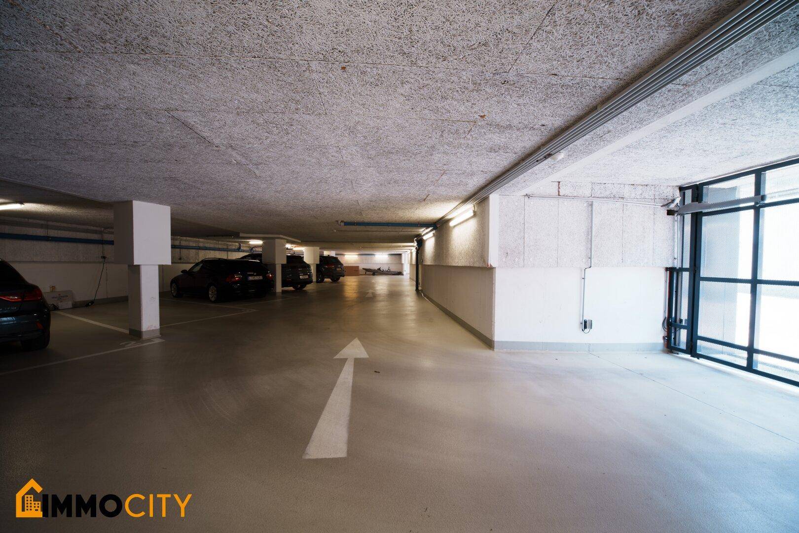 Geräumige Tiefgarage mit markierten Parkplätzen und Beleuchtung.