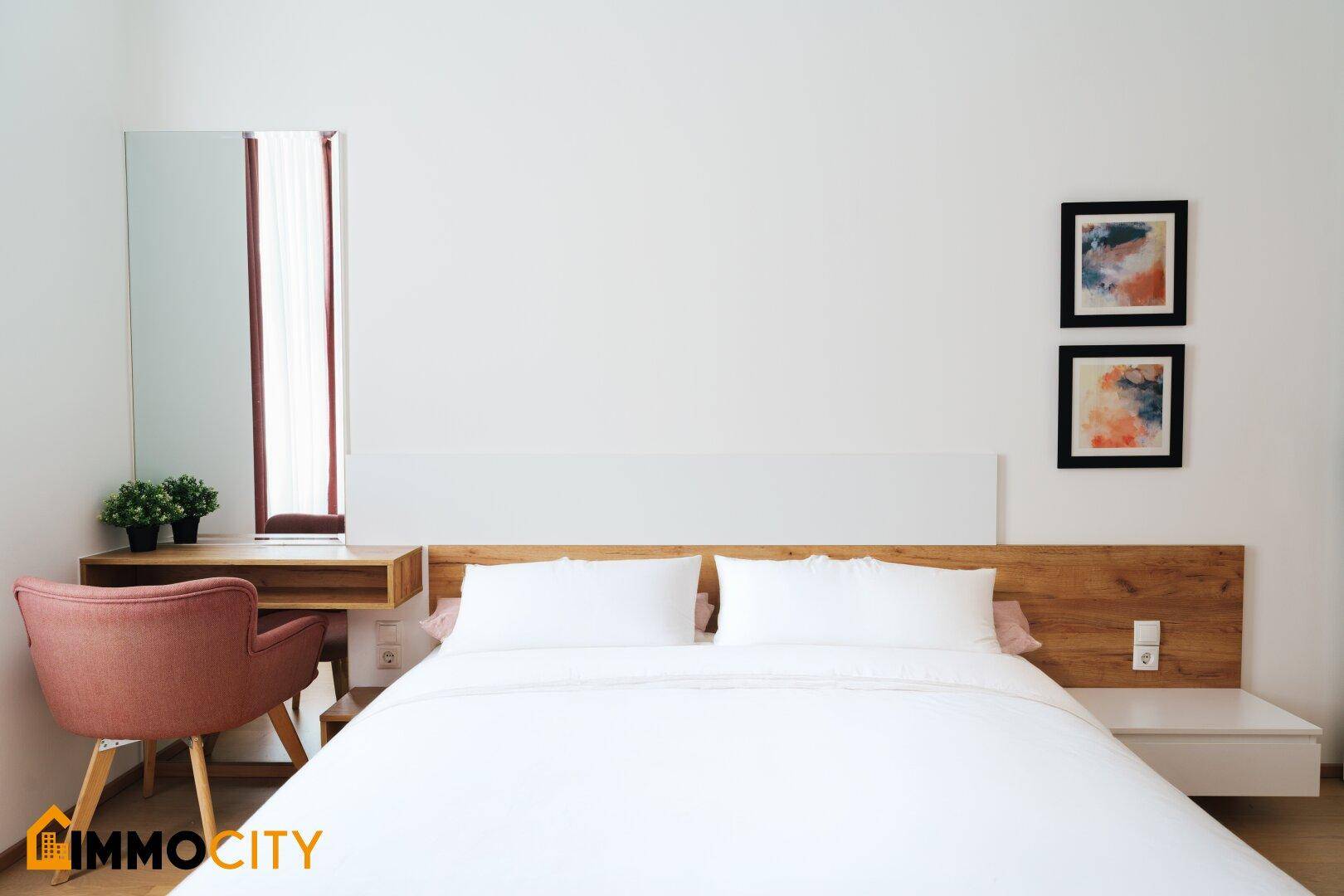 Schlafzimmer mit Holzbett, integriertem Schreibtisch und großem Spiegel.