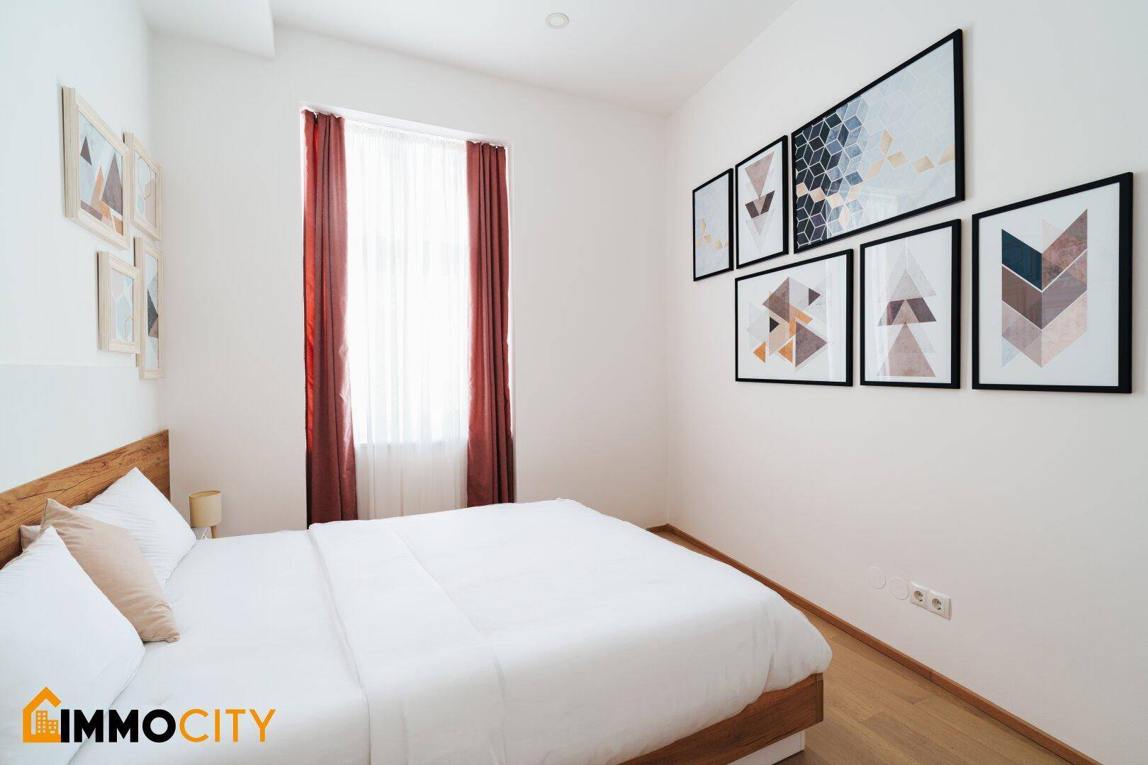 Modern eingerichtetes Schlafzimmer mit Holzbett und stilvollen geometrischen Wandbildern.